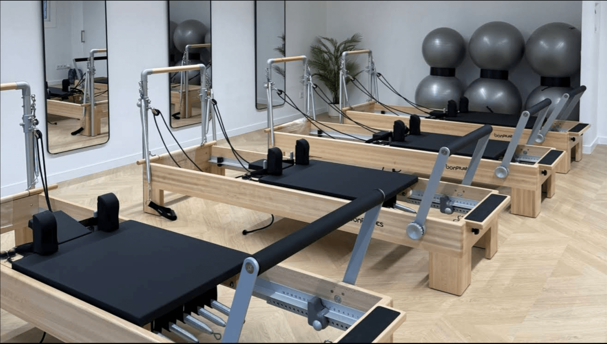 Aura Pilates Studio — sala con máquinas Reformer en Barcelona